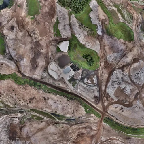 High-resolution aerial view showing complex terrain patterns, sand features, vegetation patches, and water drainage across a golf course site under development