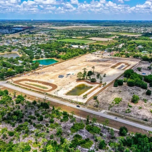 Drone capture of land grading in early development phase with retention ponds and surrounding suburban density