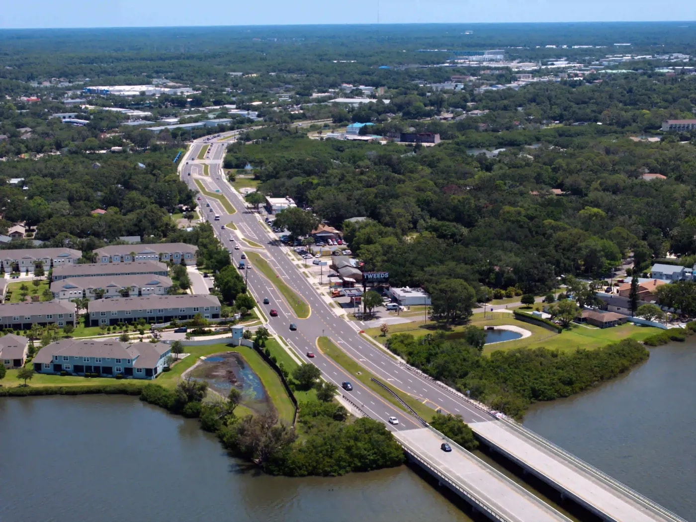 Elevated view of highway corridor flanked by suburban housing and green cover, designed for efficient vehicle flow